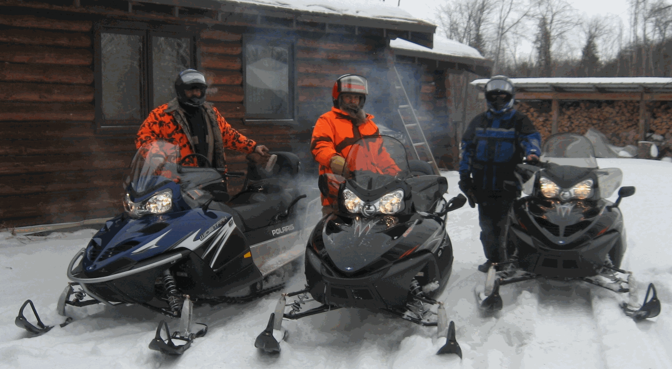 three travelers and snowmobiles